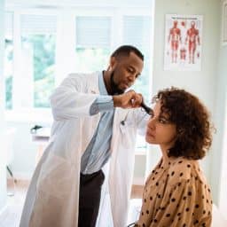 Woman gets an ear exam.