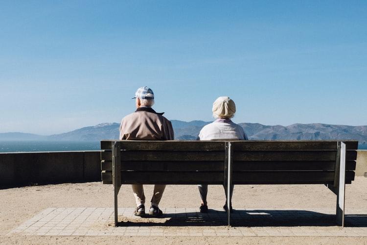 Older couple with cognitive decline from untreated hearing loss An older couple sitting on a bench together.
