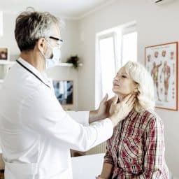 Doctor performing throat exam on patient.