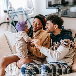 Happy family playing and talking with their baby.
