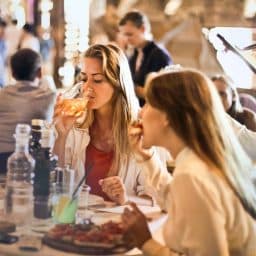 Two women dining in a busy restaurant.