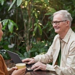 Older couple enjoying conversation at an outdoor cafe.