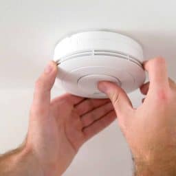 Man installing smoke or carbon monoxide detector