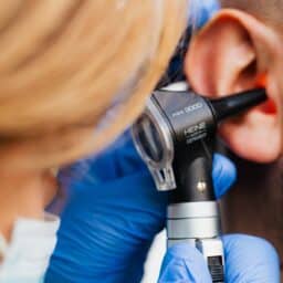 Doctor examining a man's ear.