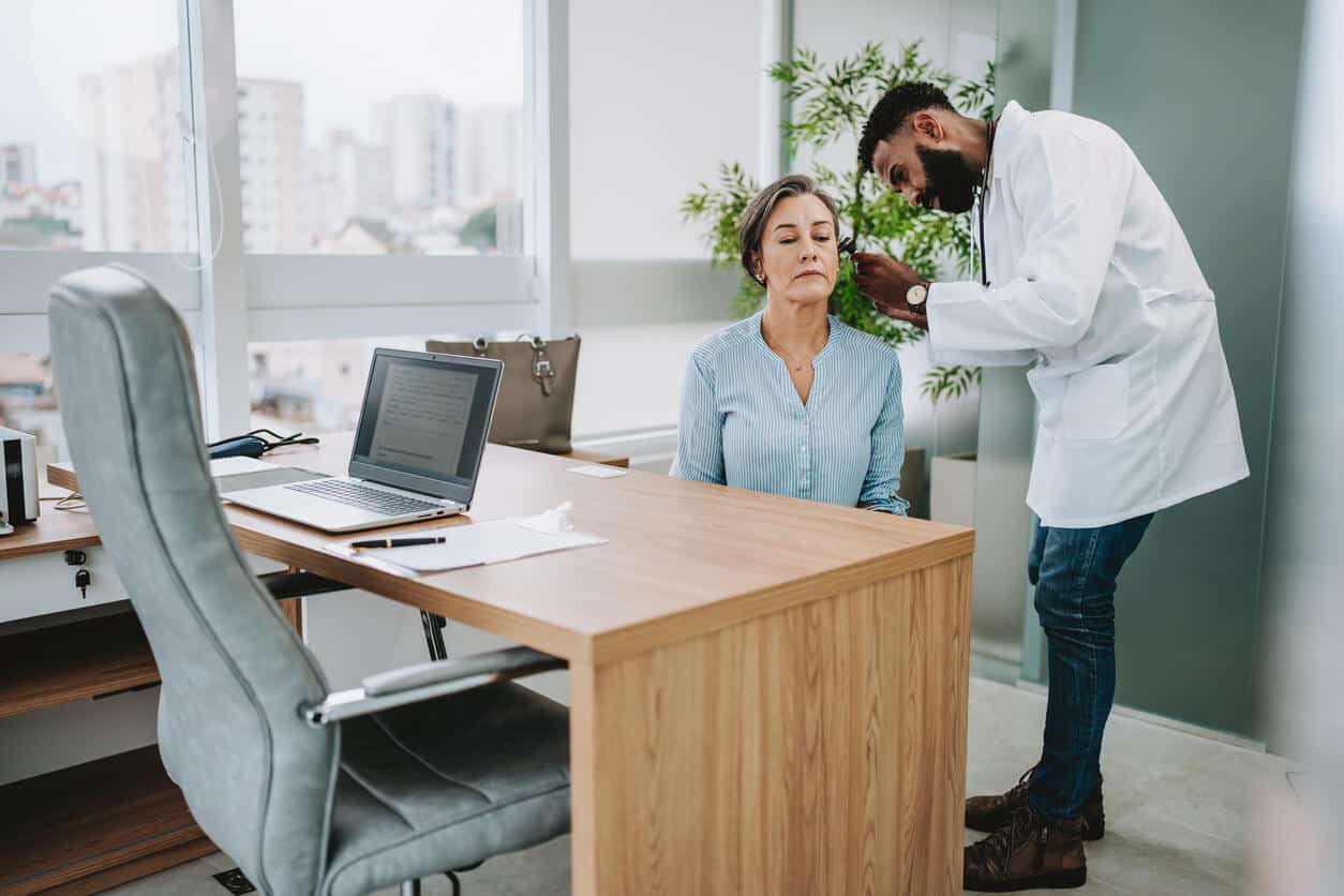 Audiologist examining a patient's ear.