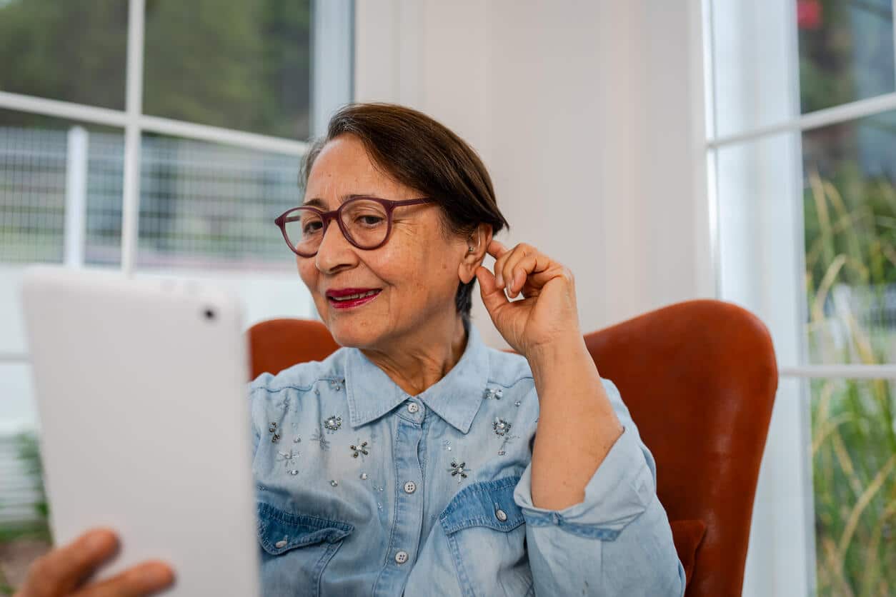 Woman checking out her new hearing aid.