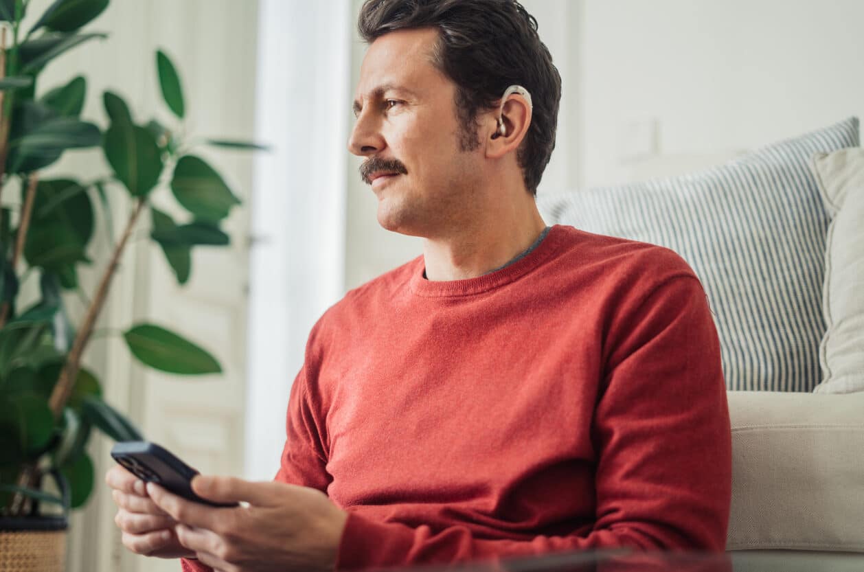 Man uses hearing aid at home