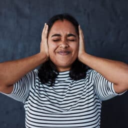 Woman experiencing tinnitus looking uncomfortable.