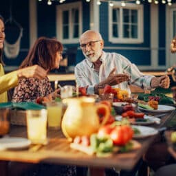 A multigenerational family gathers for a backyard barbecue on a lovely summer evening.